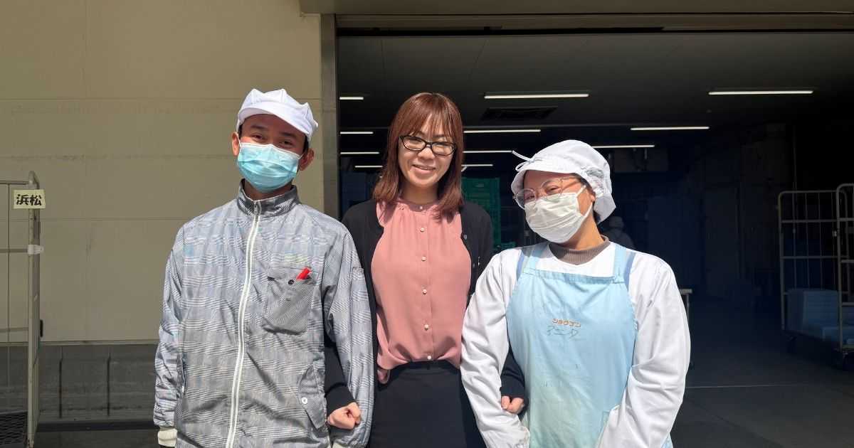 noborder導入事例：特定技能外国人を受け入れているショクブンの担当者と、特定技能外国人が笑顔で腕を組む様子
